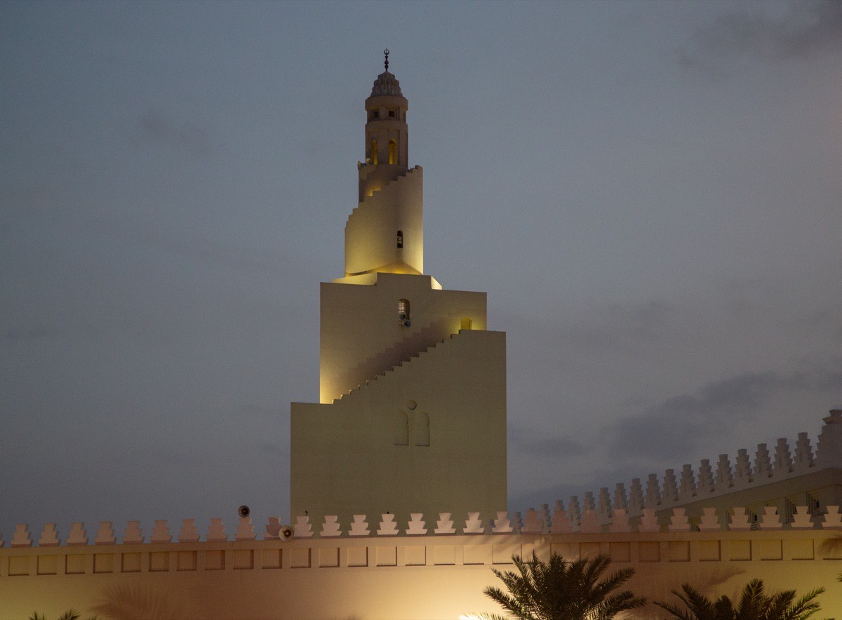 The stepped minaret of Masjid Dhul Hulayfah at Abyar Ali, the miqat for pilgrims approaching Makkah from Madinah, lit against a dusk sky.
